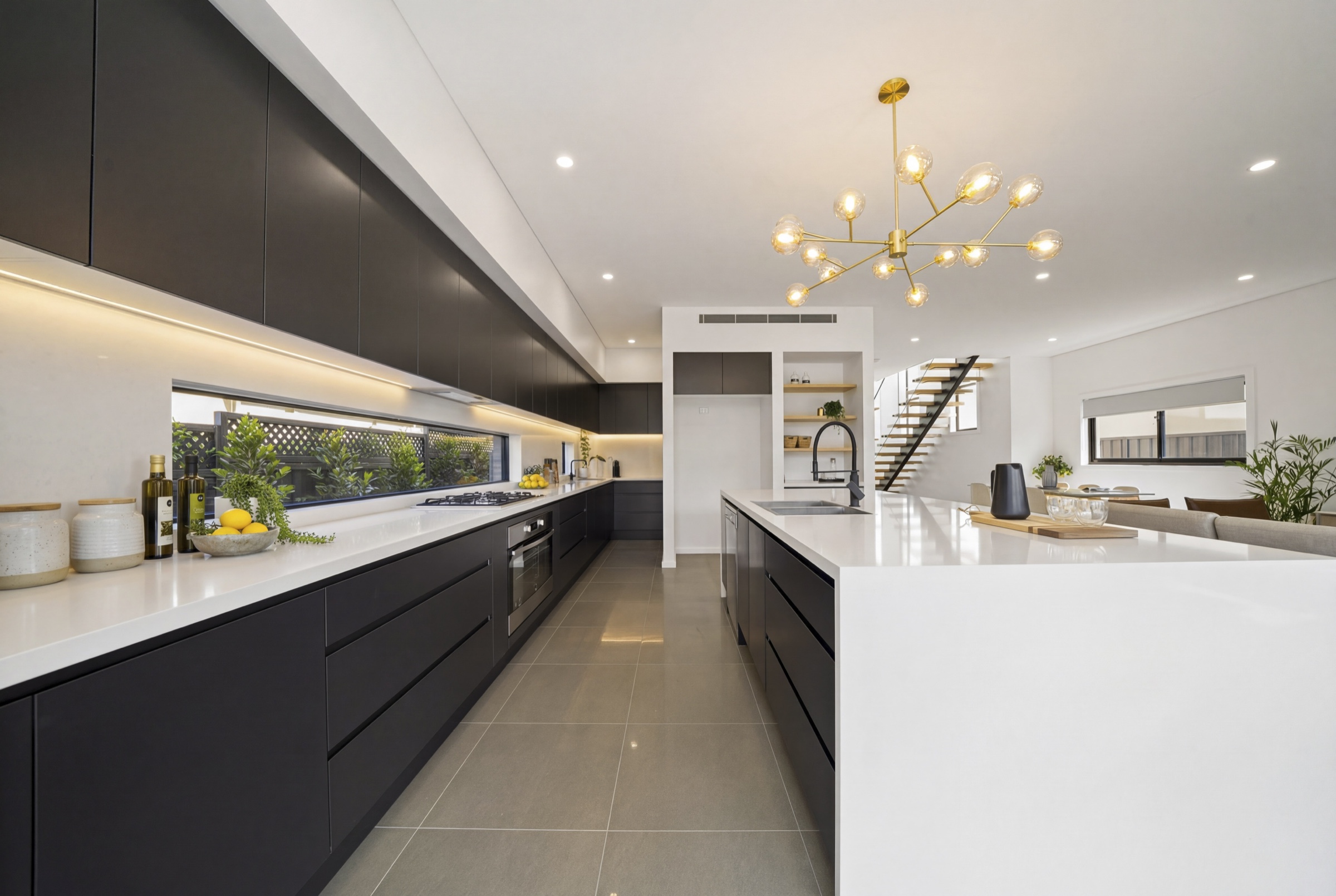 Modern black and white kitchen with a sculptural brass pendant light